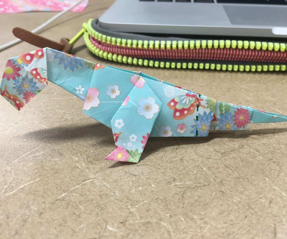 Versierde origami dinosaurus op tafel