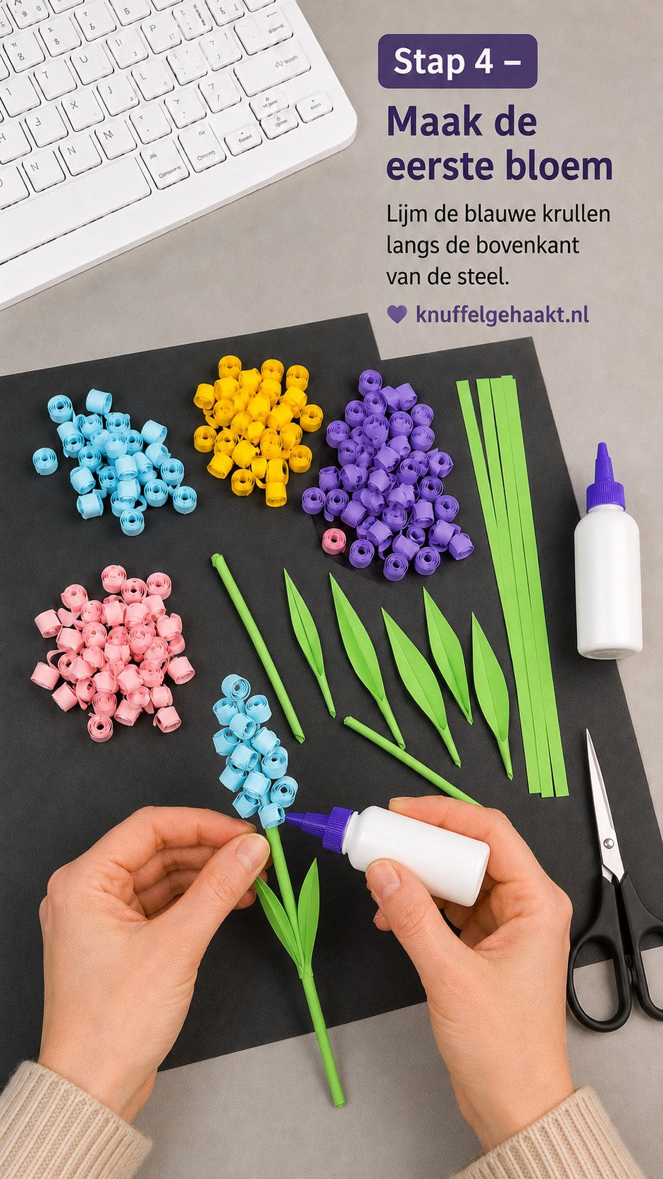 De eerste blauwe quilling hyacint krijgt zijn gerolde papieren krulletjes langs de bovenkant van de steel gelijmd.
