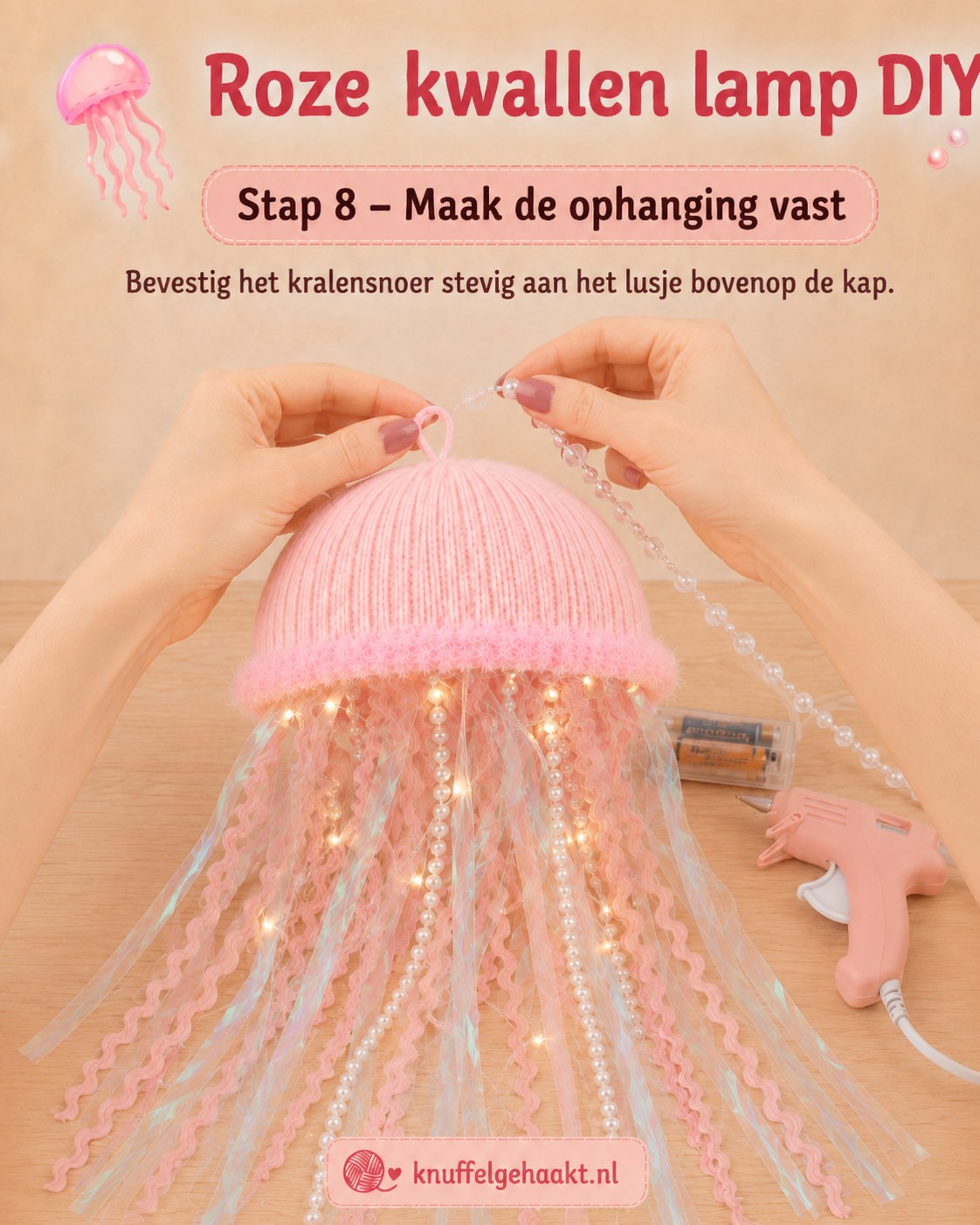 Een kralensnoer wordt stevig aan het hanglusje van de zelfgemaakte kwallenlamp bevestigd